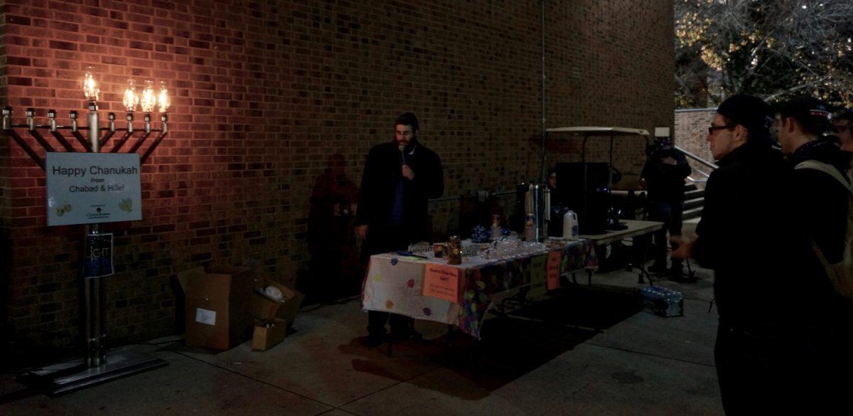 Rabbi Hersh Loschak led the lighting by reciting Hebrew blessings. -Anthony Medina/Staff Photographer