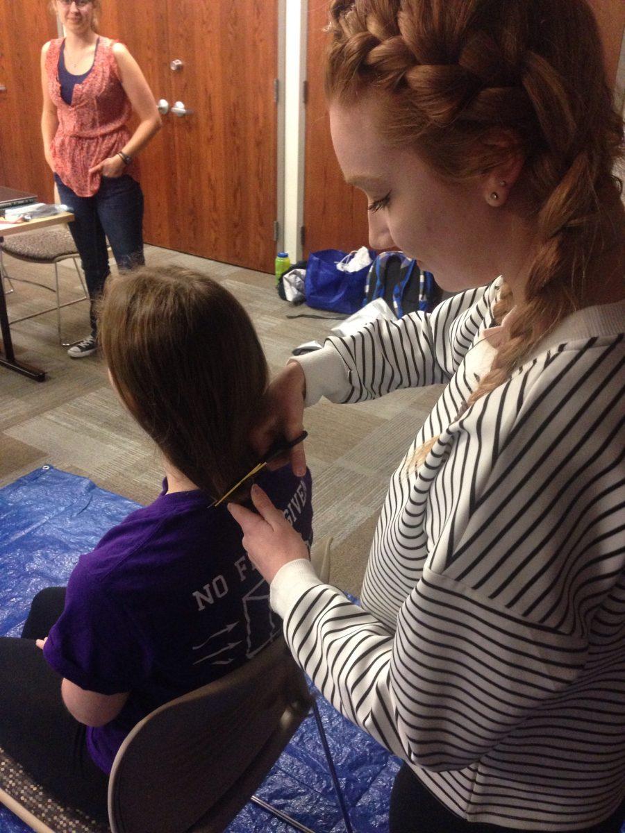 High school cosmetology student Styler Jenkins cuts off Leah Filardi's ponytail for Pantene Beautiful Lengths. - Staff photo/Taylor Henry