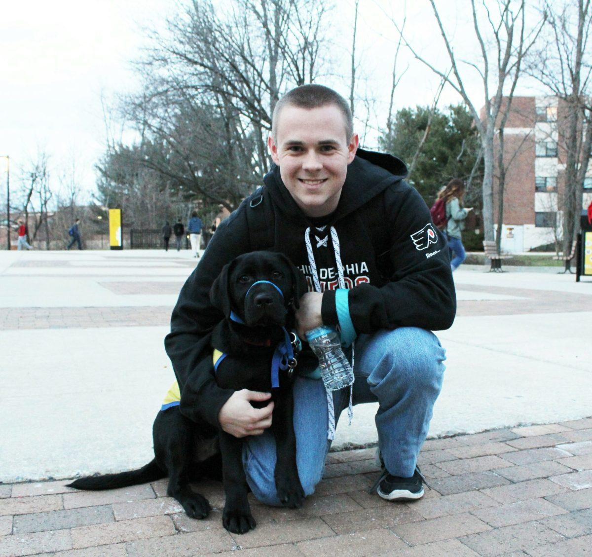 Jimmy Witkoski poses with his service dog in training, Augie. Augie is past of Rowan University’s Canine Companions for Indepence club. -Photo
Editor/Justin Fata