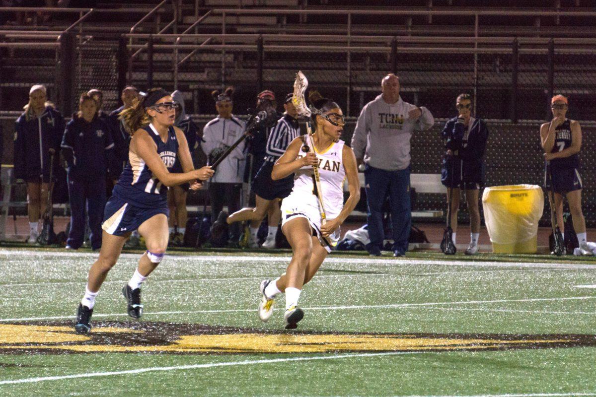 Senior Giselle Cortes runs by a TCNJ player during last night's game. The Profs fell to the Lions, 11-1. -Photo editor/Cole Ditzel