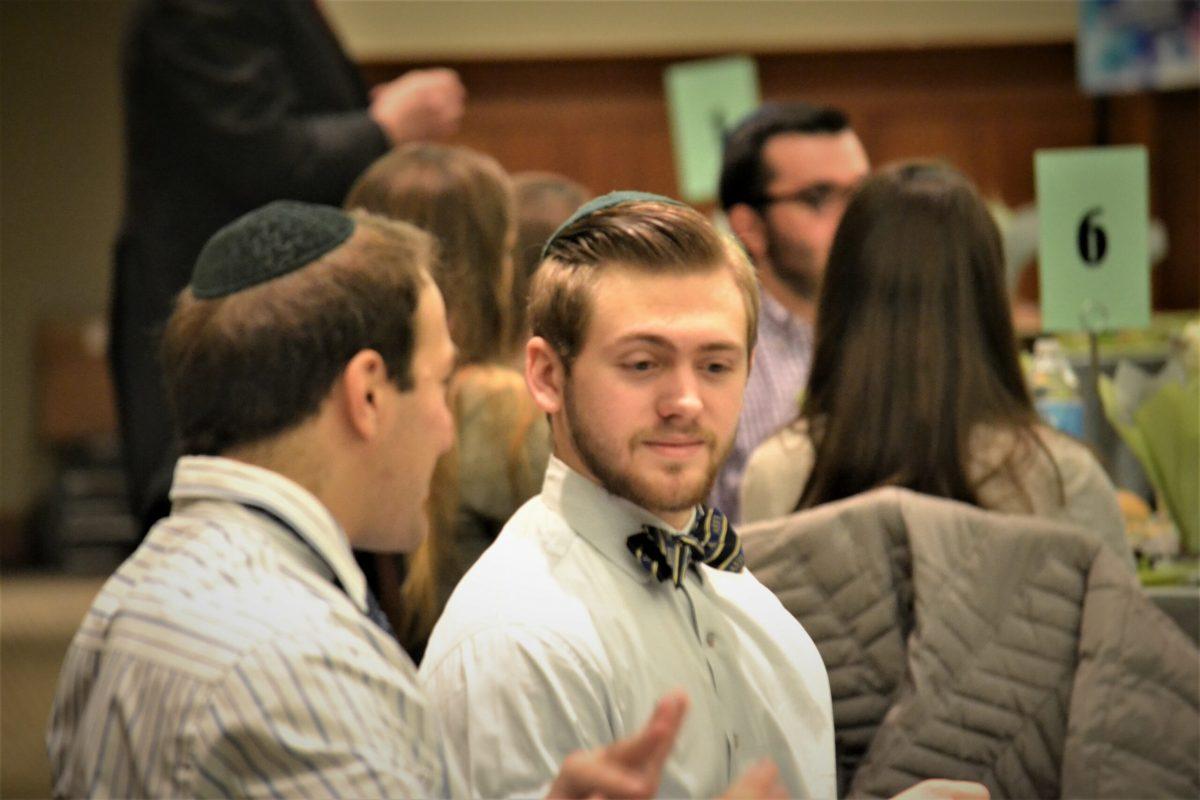 Ross Baron and Aaron Korbmin share a conversation at a table. - Staff Photo/Scott Brody