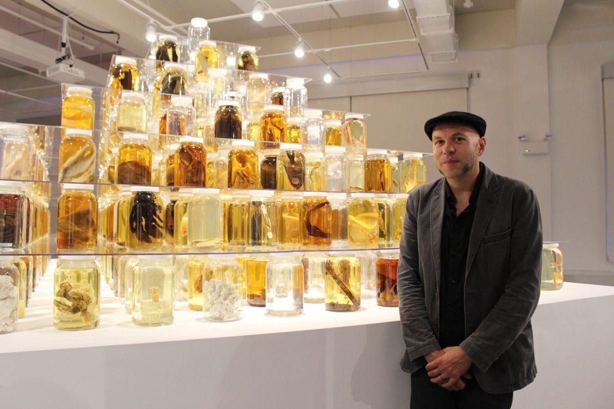 Artist and biologist Brandon Ballengée with his art piece, "Collapse." -Photo Editor/Amanda Palma