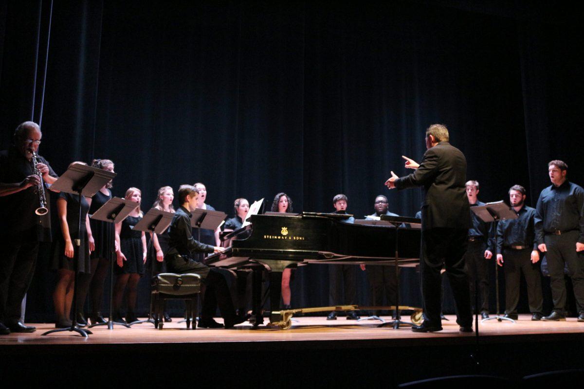 Conductor Christopher Thomas (front) and his choir perform alongside professor Denis DiBlasio (left). -Staff Photo/Maria Morales