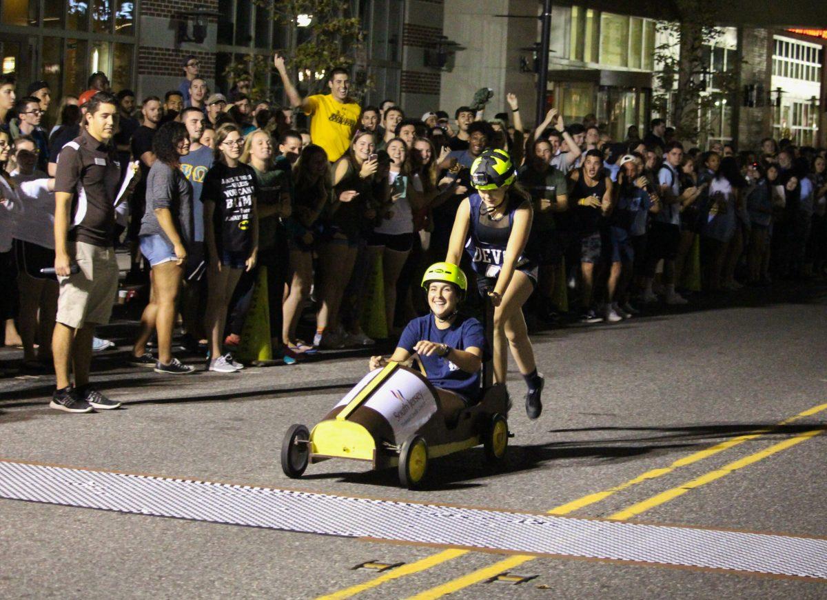 Junior secondary education majors Taylor Kankowski and Grexa, cross the finish line at the pushcart races. -Staff Photo/Jaryd Leady