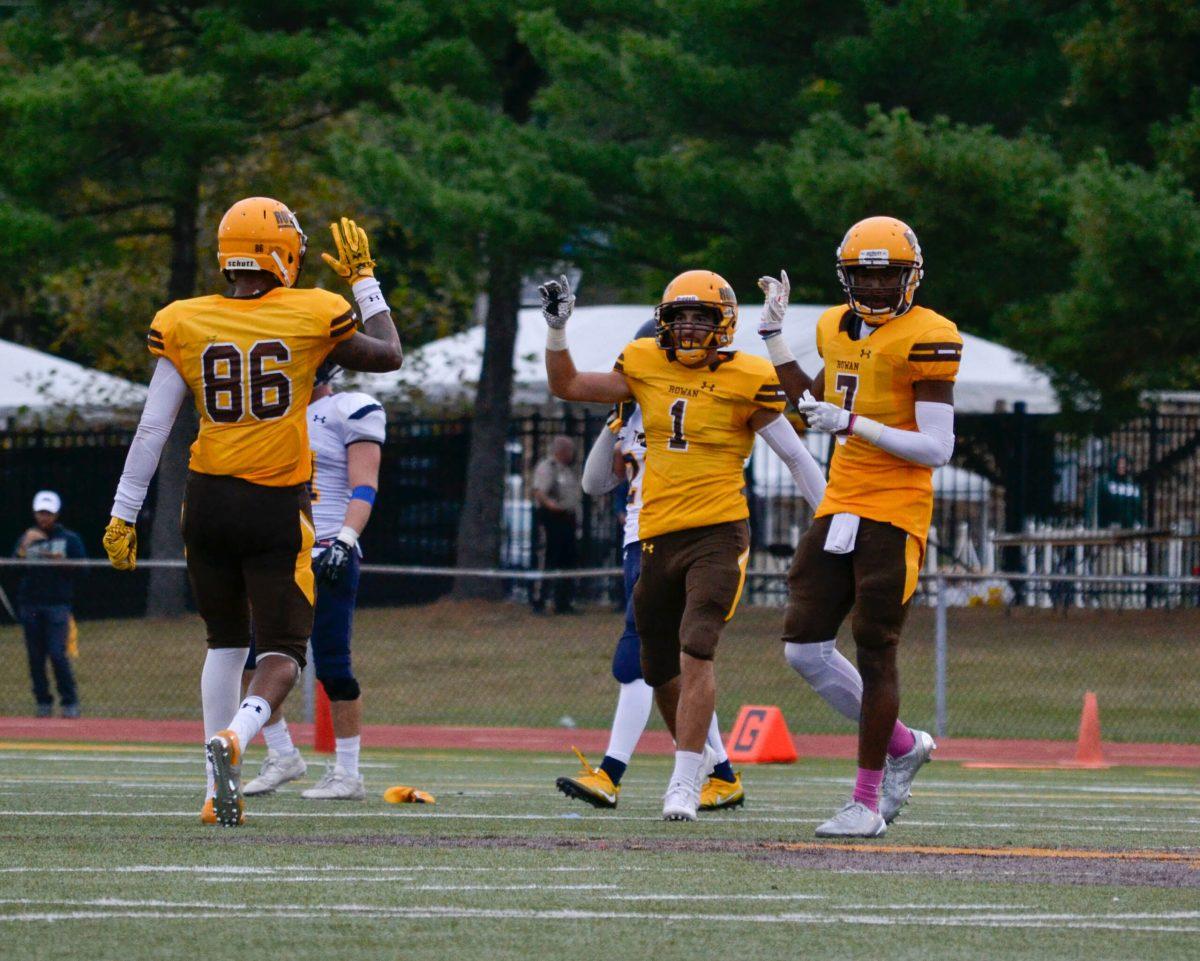 Wide receivers J.J. Kulcsar and Victor Solis-Mays celebrate with tight end Mika Graham last week against The College of New Jersey. Photo Editor/Nicole Mingo