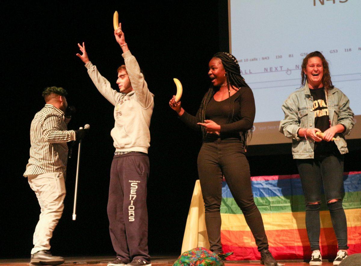 Students place a condom on a banana during a Sex Toy Bingo mini-game. -Staff Photo/Maria Morales