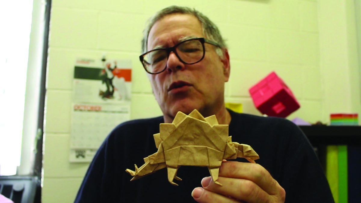 Professor of Mathematics, Ira Fine, handles an origami stegosaurus. -Staff Photo/Justin Decker