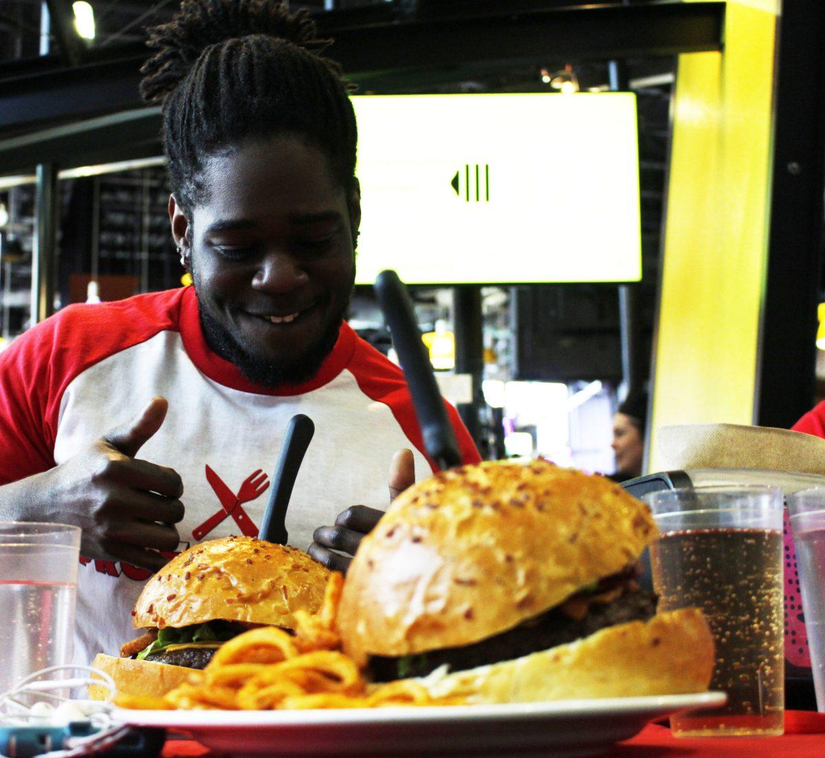 Math education junior Nick Sokoya, gets ready to eat his 22 ounce hamburger at Prof vs Food in the Marketplace cafeteria on Feb. 1. -Staff Photo/Justin Decker