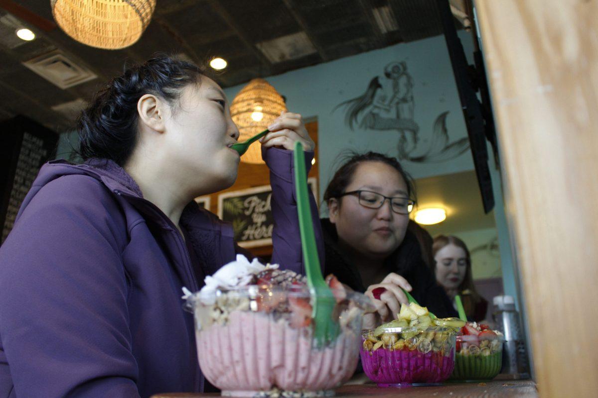 (From left to right) Glassboro resident Julie Kilman, 33, and Elizabeth Seou, 30, enjoy free acai bowls at the Playa bowls grand opening on Jan. 26. -Staff Photo/Justin Decker