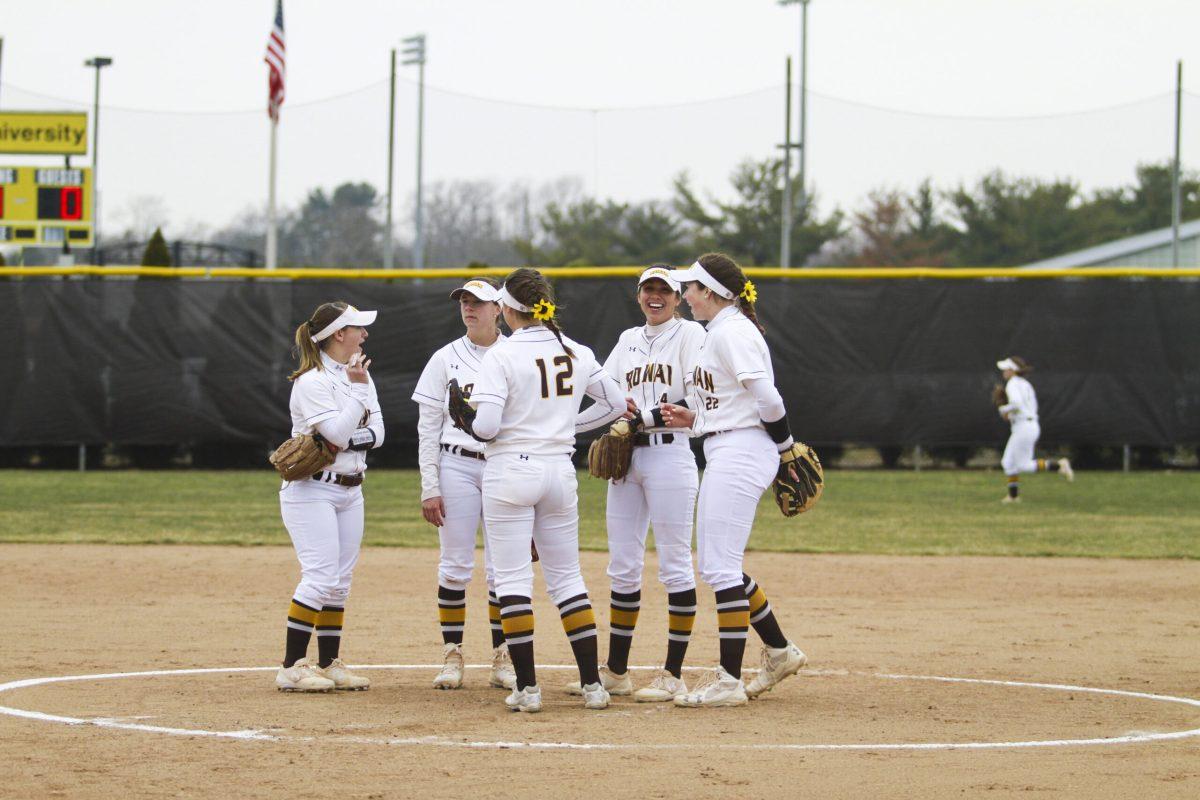 The Rowan softball team shares a laugh at the mound during a 3-0 victory over MIT. Assistant Photo Editor/Miguel Martinez