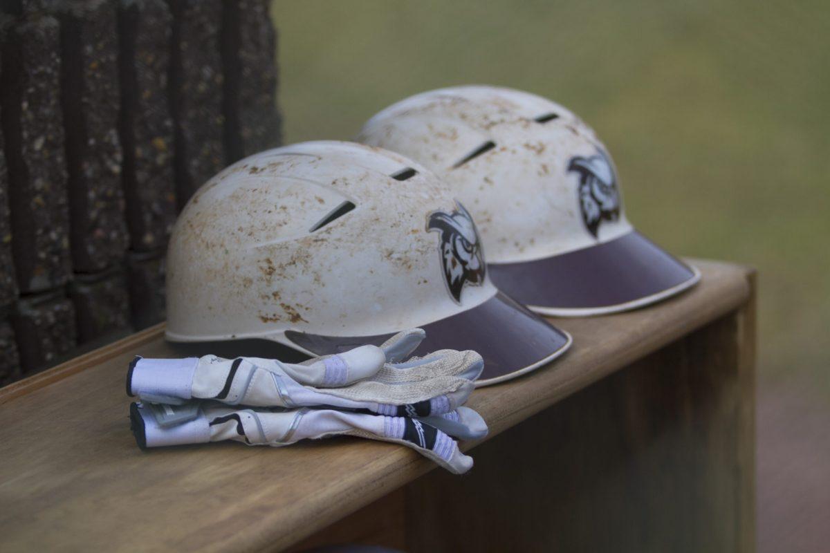 Rowan baseball team helmets and gloves sit on a bench. - File Photo / Miguel Martinez.