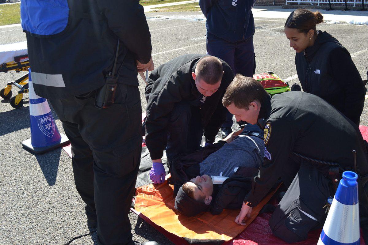 Rowan EMS members Lt. Salvatore Toppi, Sgt. Nick Henderson and Caroline Alemany are assisted by a member of the TCNJ EMS in tending to a patient. -Assistant News Editor/Mackenzie Fitchett