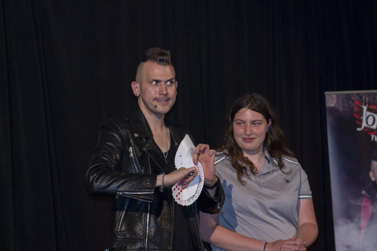 Comedy magician Joel Meyers performs a card trick with the help of assistant, freshman biomedical engineering major Alexandrea Zaburski. - Arts & Entertainment Editor/Tara Lonsdorf