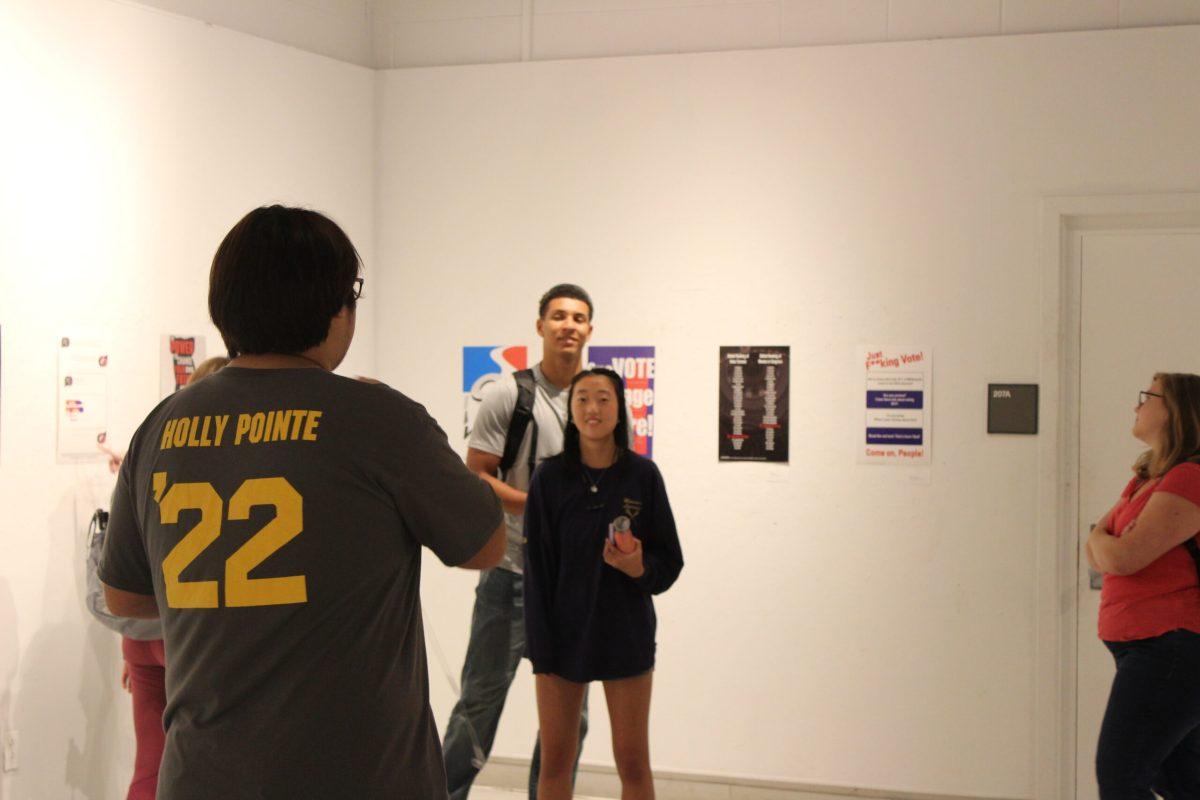 Students gather in the Westby Student Gallery to view the "Register. Vote." exhibit. - Tara Lonsdorf / Arts & Entertainment Editor