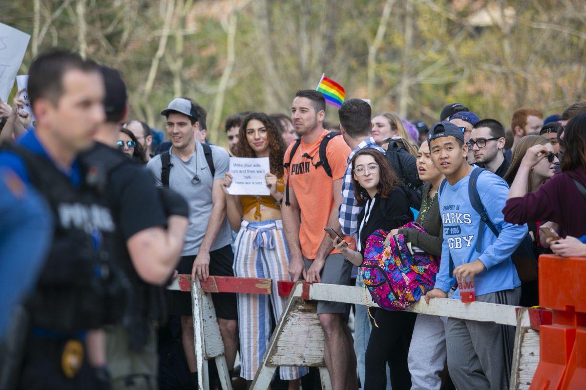 Students stand behind the barricade set up at Thursday's protest of religious demonstrators. -Multimedia Editor/Miguel Martinez