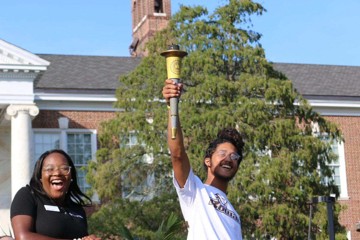 Nicholas Alexandros Mercados celebrates with SGA President Arielle Gedeon as he's passed the Torch of Knowledge. Photo by Alexander Heller