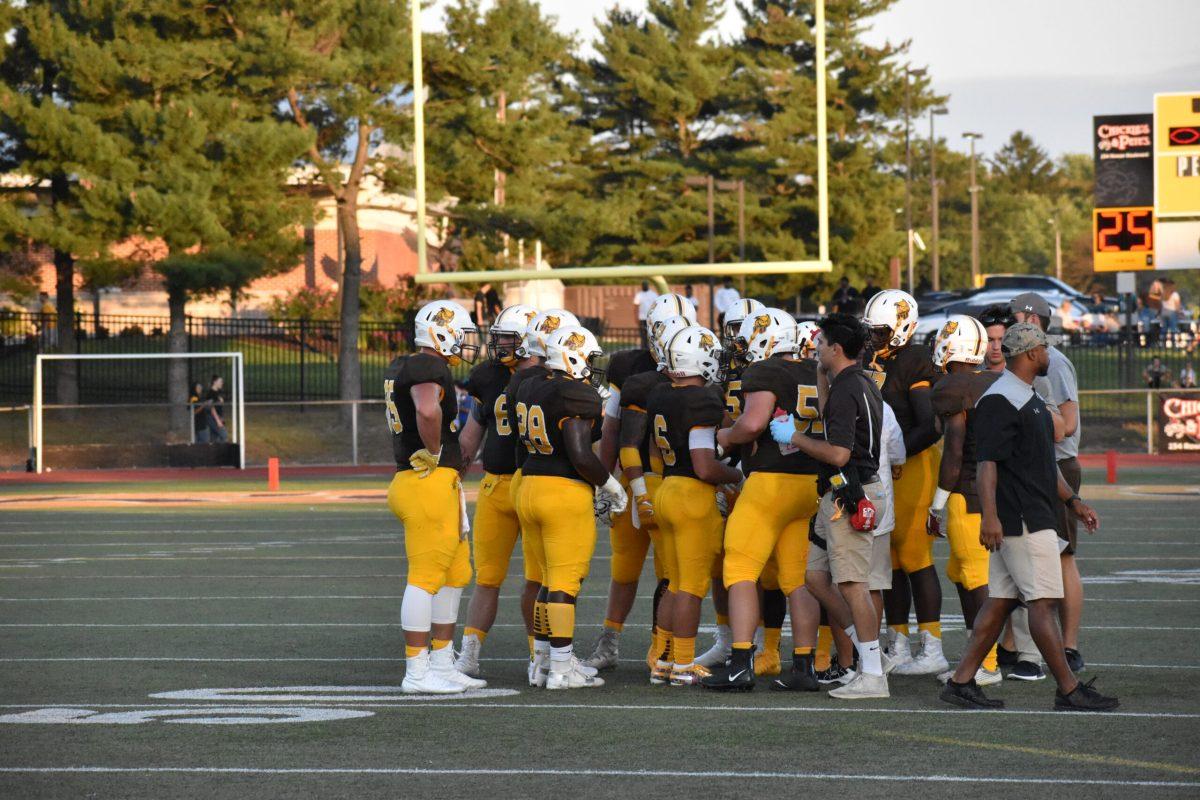 The football team in a huddle during the home opener against Widener this year. Photo/ Multimedia Editor Christian Browne