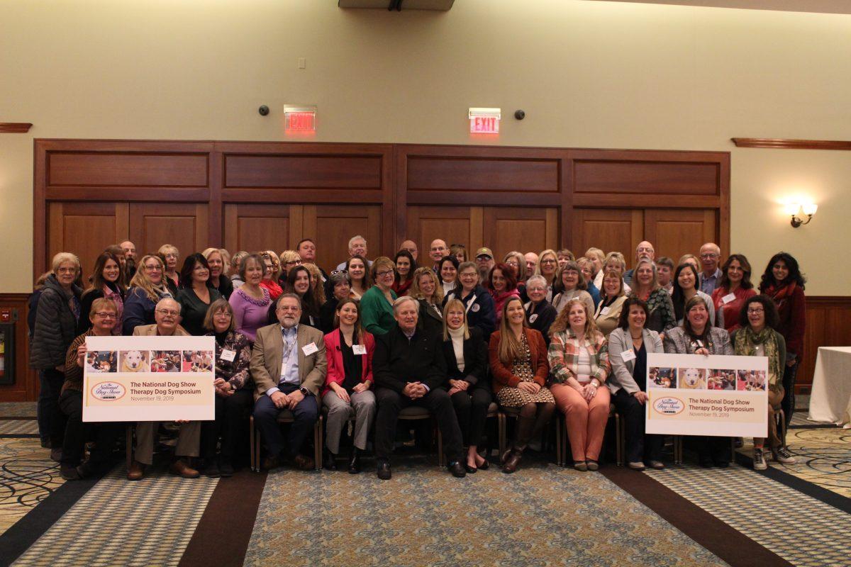 Attendees of the National Dog Show Therapy Dog Symposium pose for a picture. The symposium was held at the beginning of November to bring together the therapy dog community. - Staff Writer / Kristin Guglietti