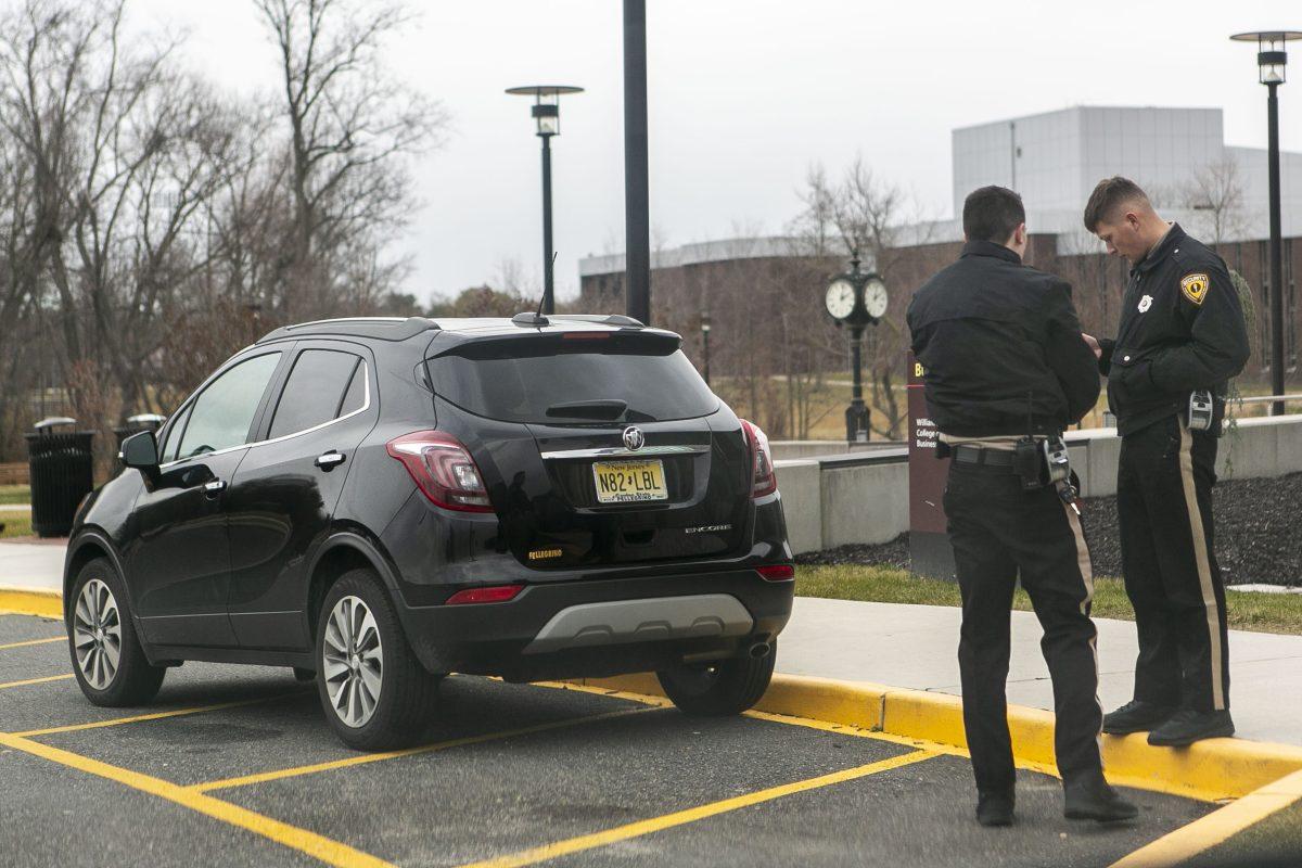 Rowan's parking enforcement process a ticket to an illegally parked car at Rowan's Glassboro Campus. - Editor-in Chief / Miguel Martinez 