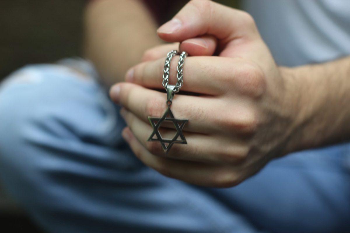 Rowan senior Alexander Rossen holds a Magen David necklace to honor his Jewish culture and beliefs - but does Rowan University have the same respect for religious plurality? - Photo by Brian Lawrence. Used with permission.