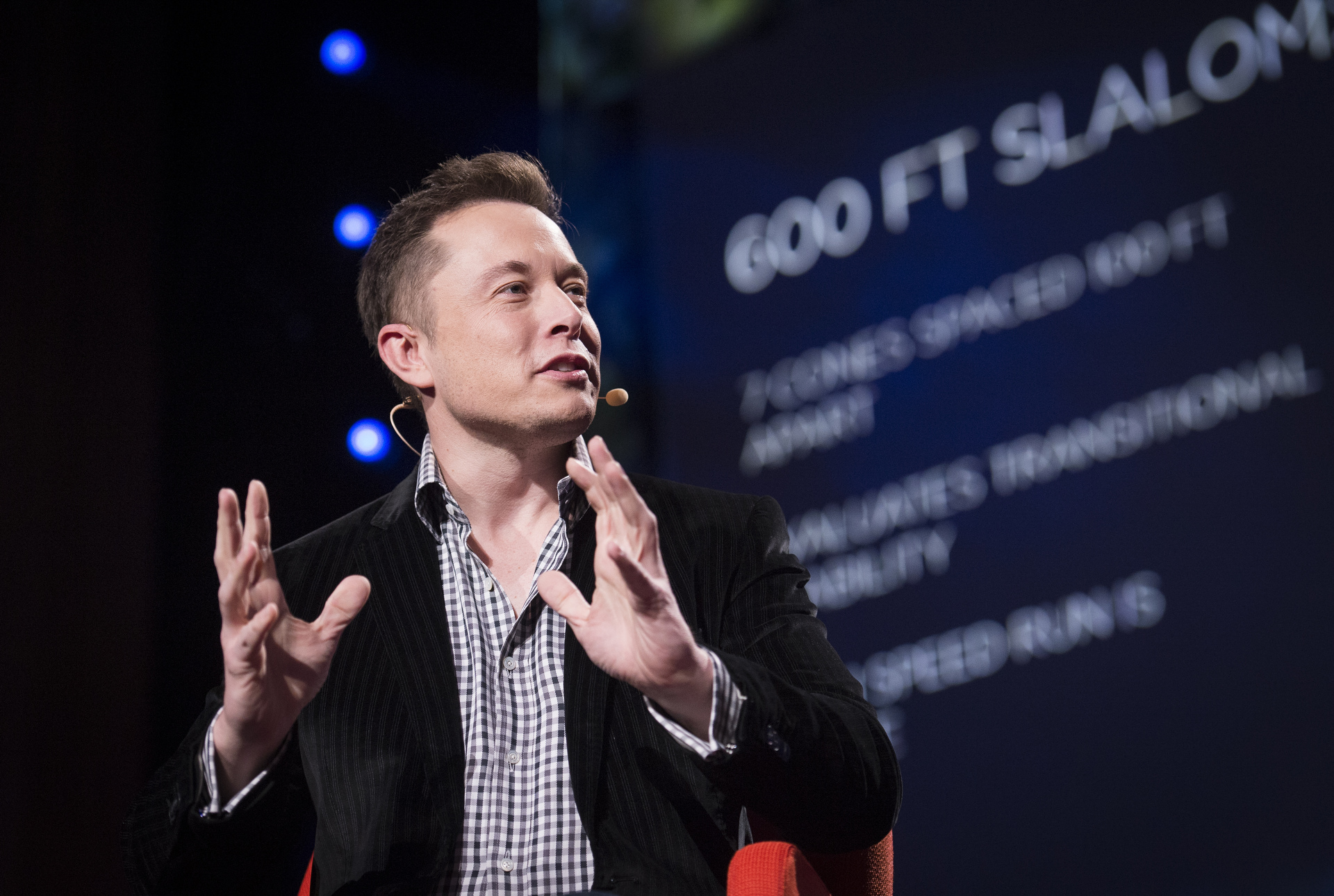 elon musk speaking on stage with microphone