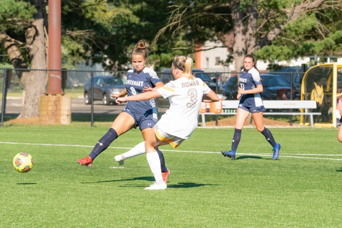 Aiden Sheehan kicking the ball past a defender in Rowan's game against Centenary University. Sheehan had two goals in the game. Saturday, Sept. 4, 2021. - Multimedia Editor / Nick Feldman