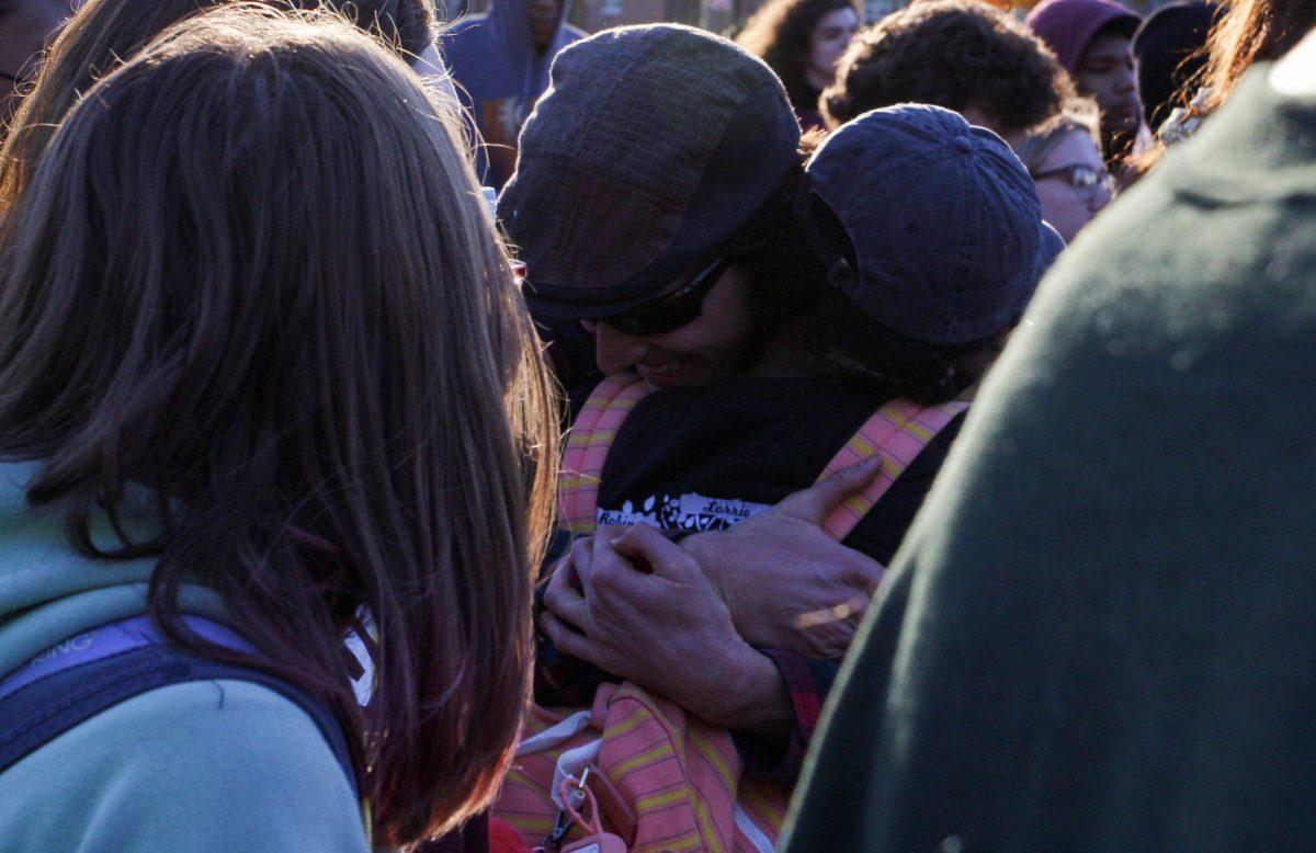 Attendees of Monday's rally hug outside of Savitz Hall. - Multimedia Editor / Alex Rossen