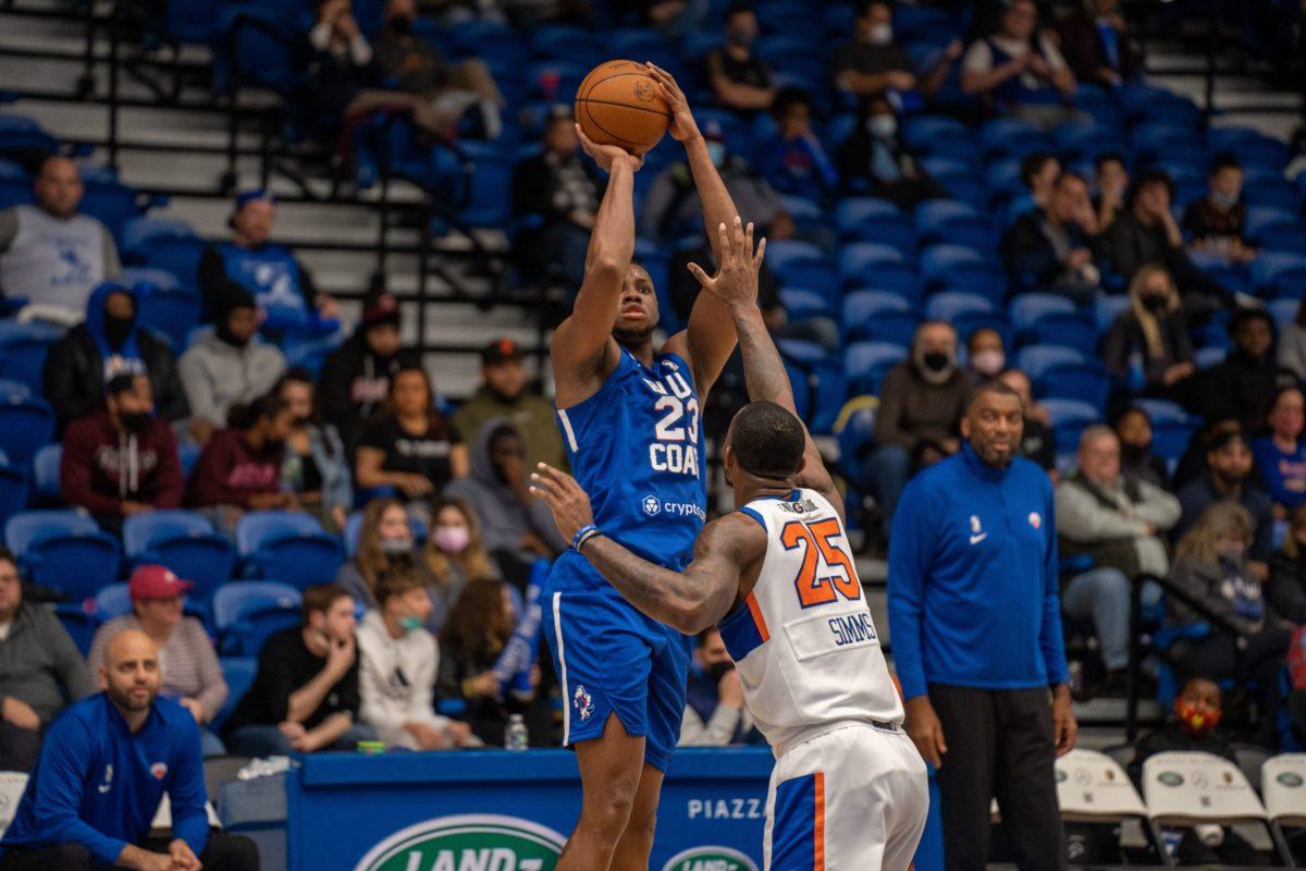 Blue Coat's Charles Bassey taking a shot over a Knicks defender. Bassey would record a double-double in the Blue Coat's 93-91 victory over the Knicks. Friday, Dec. 17, 2021. - Staff Photographer / Joey Nicolo