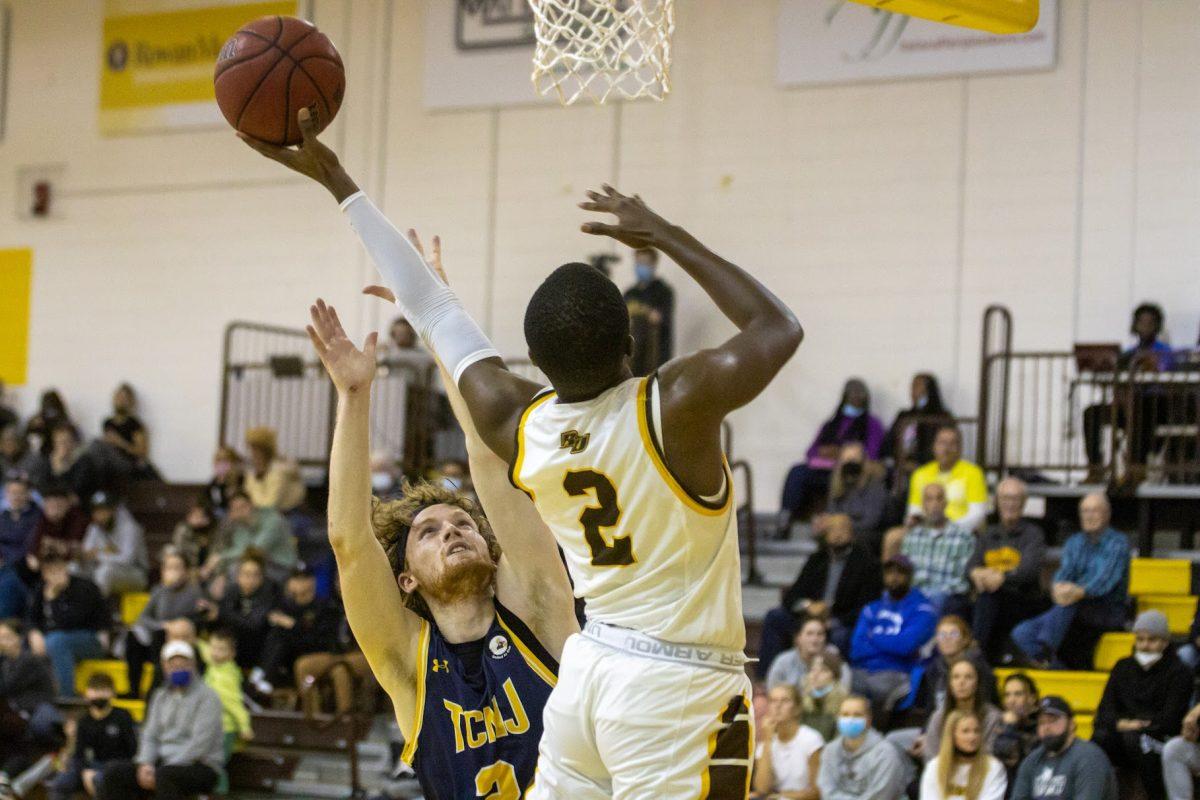 Rowan's Marcellus Ross going up for a layup with a TCNJ player trying to contend it. Ross was one of Rowan's leading scorers on Wednesday night against TCNJ with 20 points. Wednesday, Jan. 19, 2022. - Multimedia Editor / Lee Kotzen