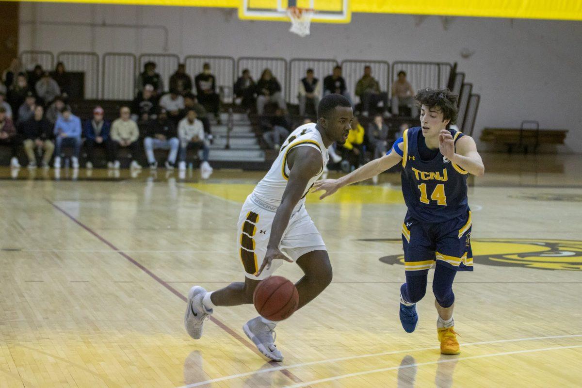 Rowan's Marcellus Ross dribbling past a TCNJ defender. Ross has been one of Rowan's top performers this season. Wednesday, Jan. 19, 2022. - Multimedia Editor / Lee Kotzen