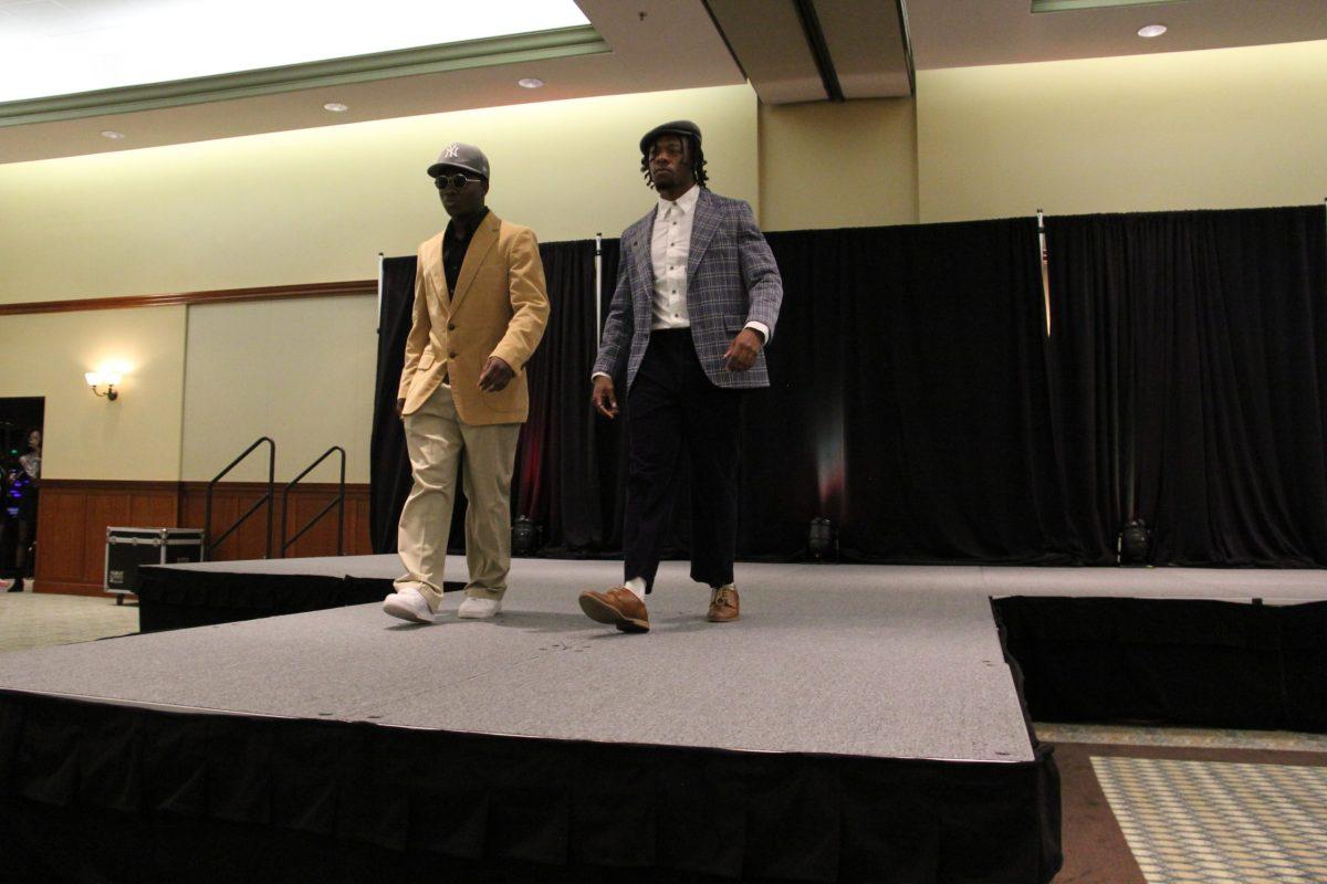 Two models walk the runway during the "Blast from the Past" fashion show during RAH's Black History Month event. This event shared the cultural changes of fashion over time. - Photo / Kariyah Bennett