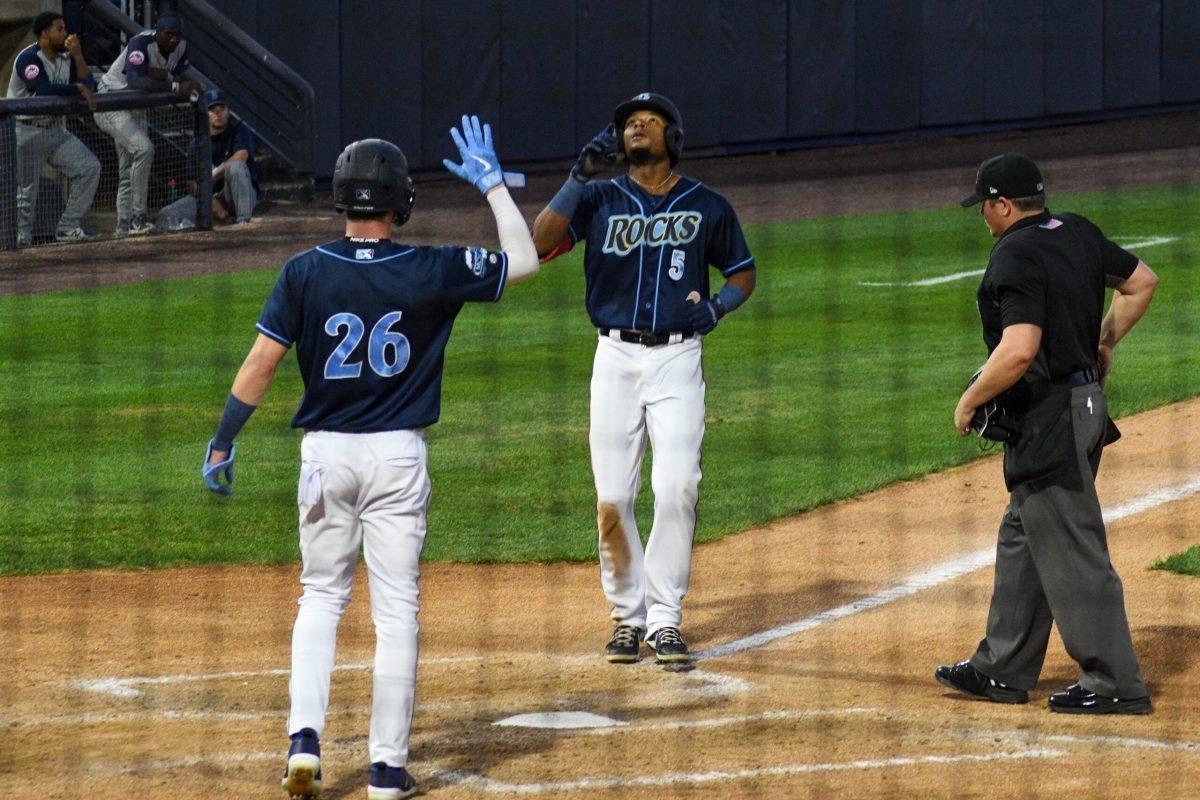 Robert Hassell III waits for Yasel Antuna at the plate after his home run. Hassell and Antuna recorded a combined total of five hits and five RBIs in their Friday night victory. Friday, August 12, 2022. - Staff Photographer / Tyrese Williams