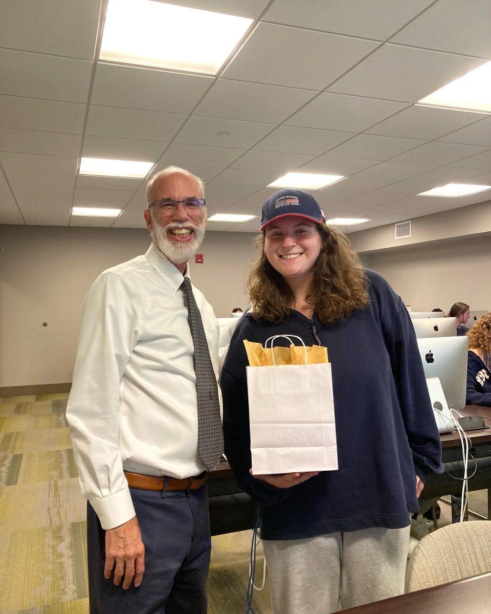 Contest winner Ileana Koifman receives her winnings from Tweedie. / Photo via the Edleman College of Communication & Creative Arts