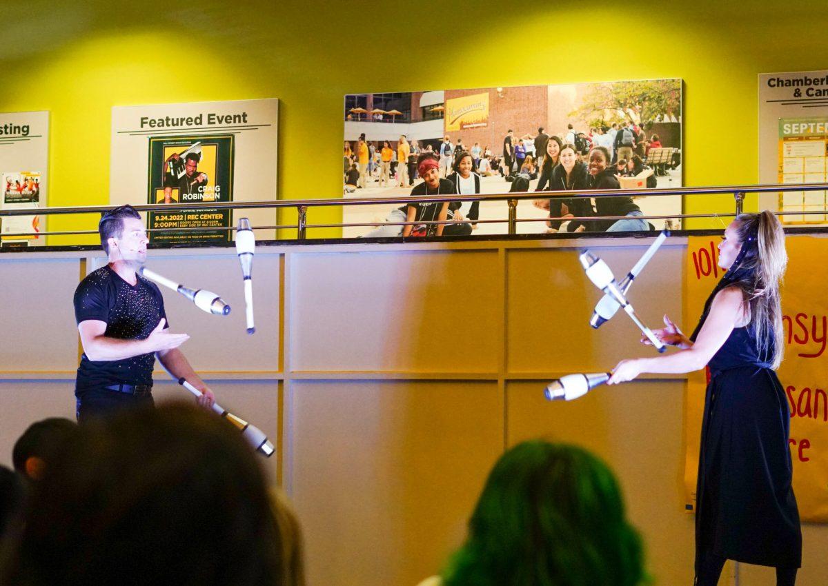 Michael DuBois and Viktoria Grimmy juggle bowling pins in front of Rowan students - Contributor / Edi Doh