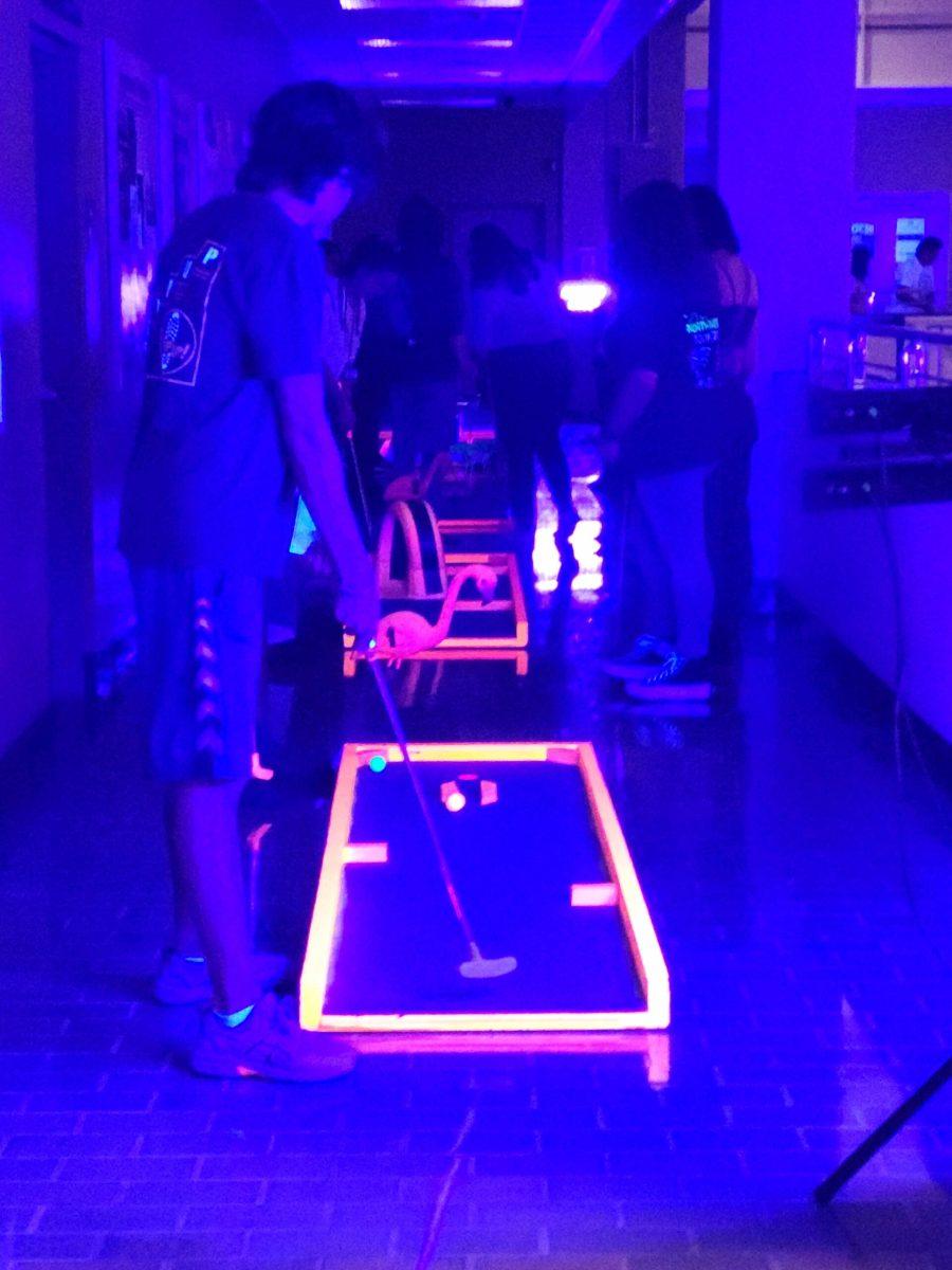 Students putt through the Blacklight Mini-Golf Course. - Contributor / Nick Butler 