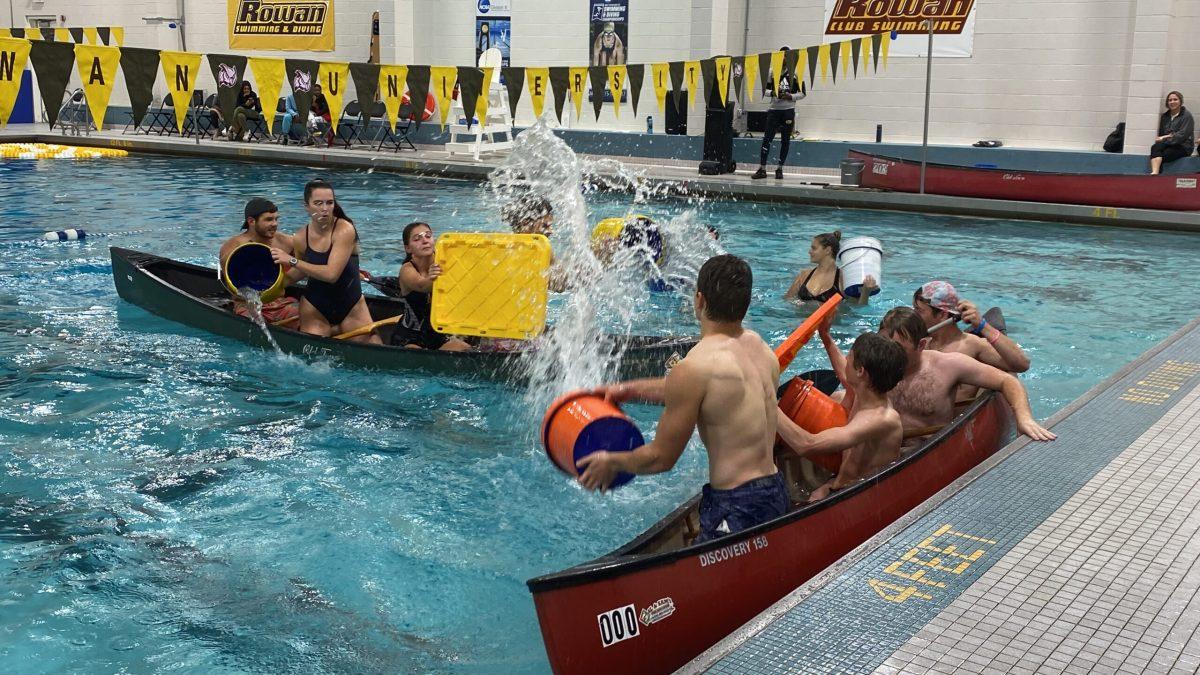 Men’s Ultimate Frisbee tosses water into the Club Swimming boat, while the swimming team shields it away. - Staff Writer / Madison Miller