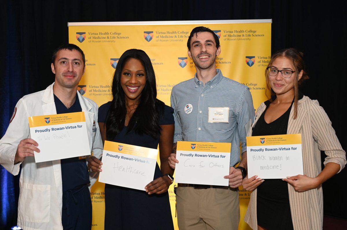 Guests at the invitation-only event in Stratford received a sign with the phrase "Proudly Rowan-Virtua for" that they were asked to complete in their own words and then hold up for the camera. - Photo / Rowan University