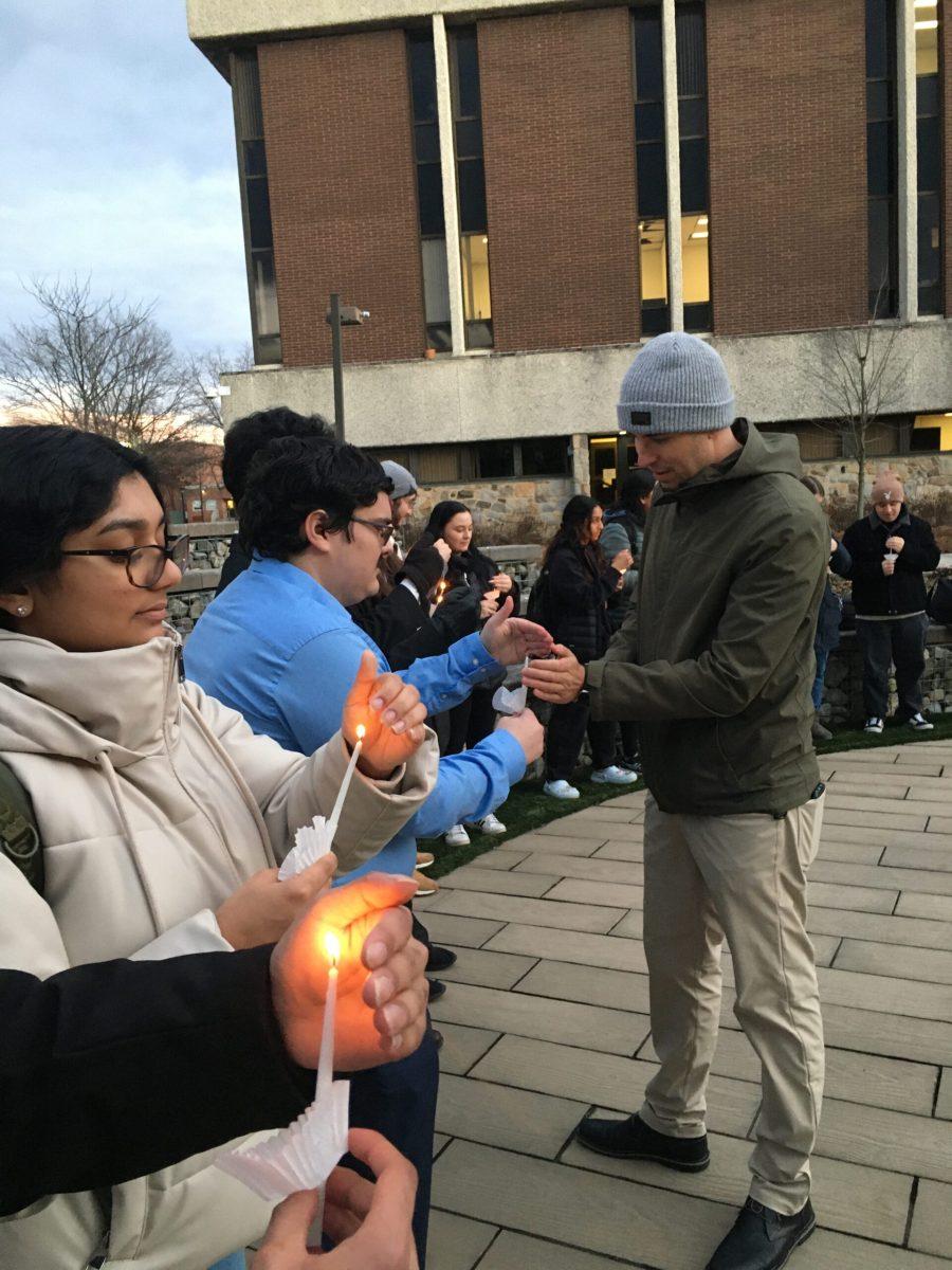 Students gather in Robinson Circle to light candles in remembrance of victims of the Holocaust. From left to right, Anushree Chauhan, Rory Newman and Dr. Mikkel Dack - Photo / Abigail Twiford