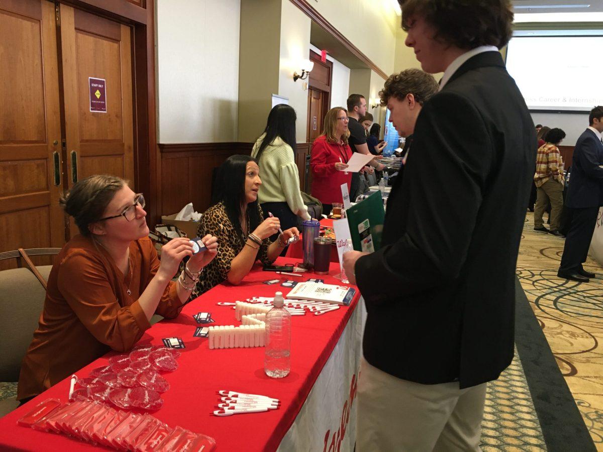 Marketing senior Ryan Collins speaks with Kayla Beckman at the Walgreens table. - News Intern / Abigail Twiford 