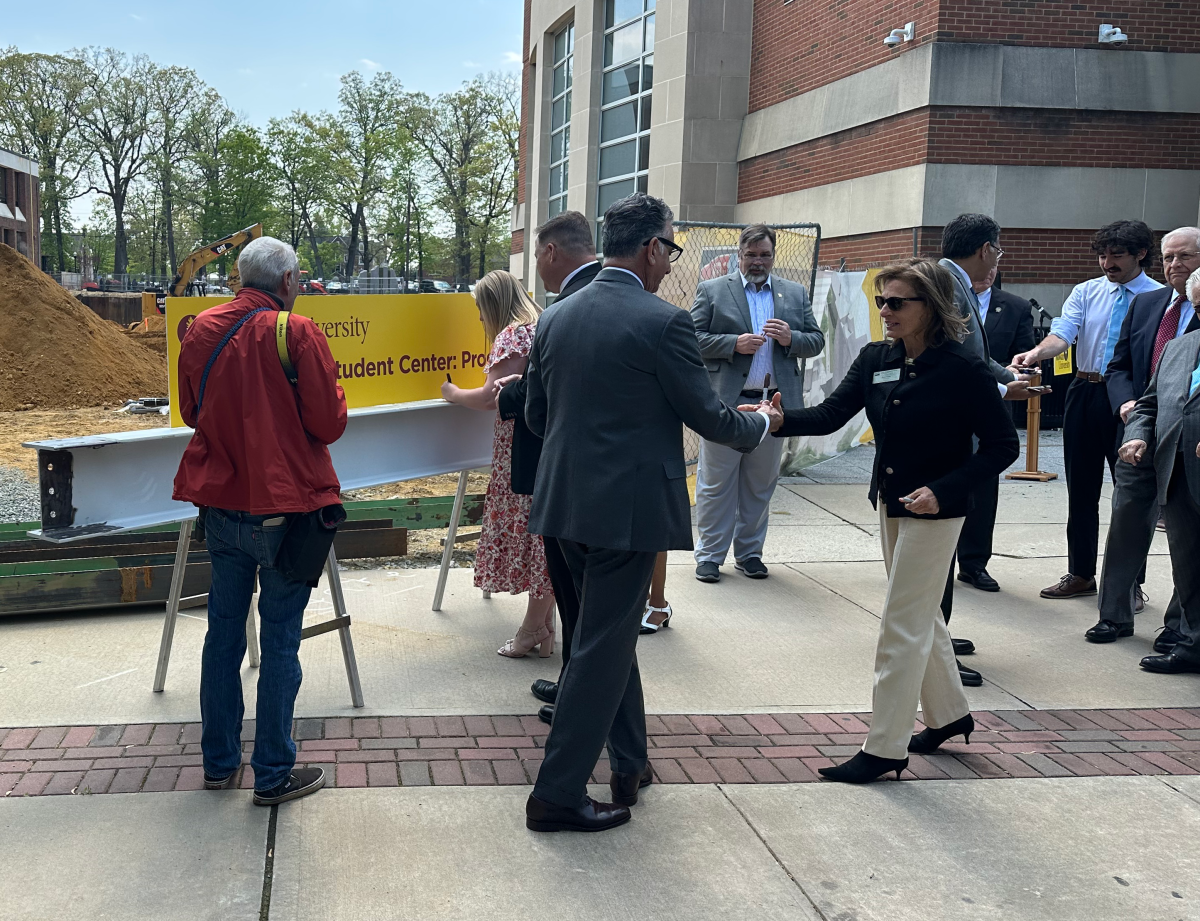 President Ali Houshmand grabs a mark to sign the beam that will be apart of the new infrastructure. - News Intern / Connor Brown