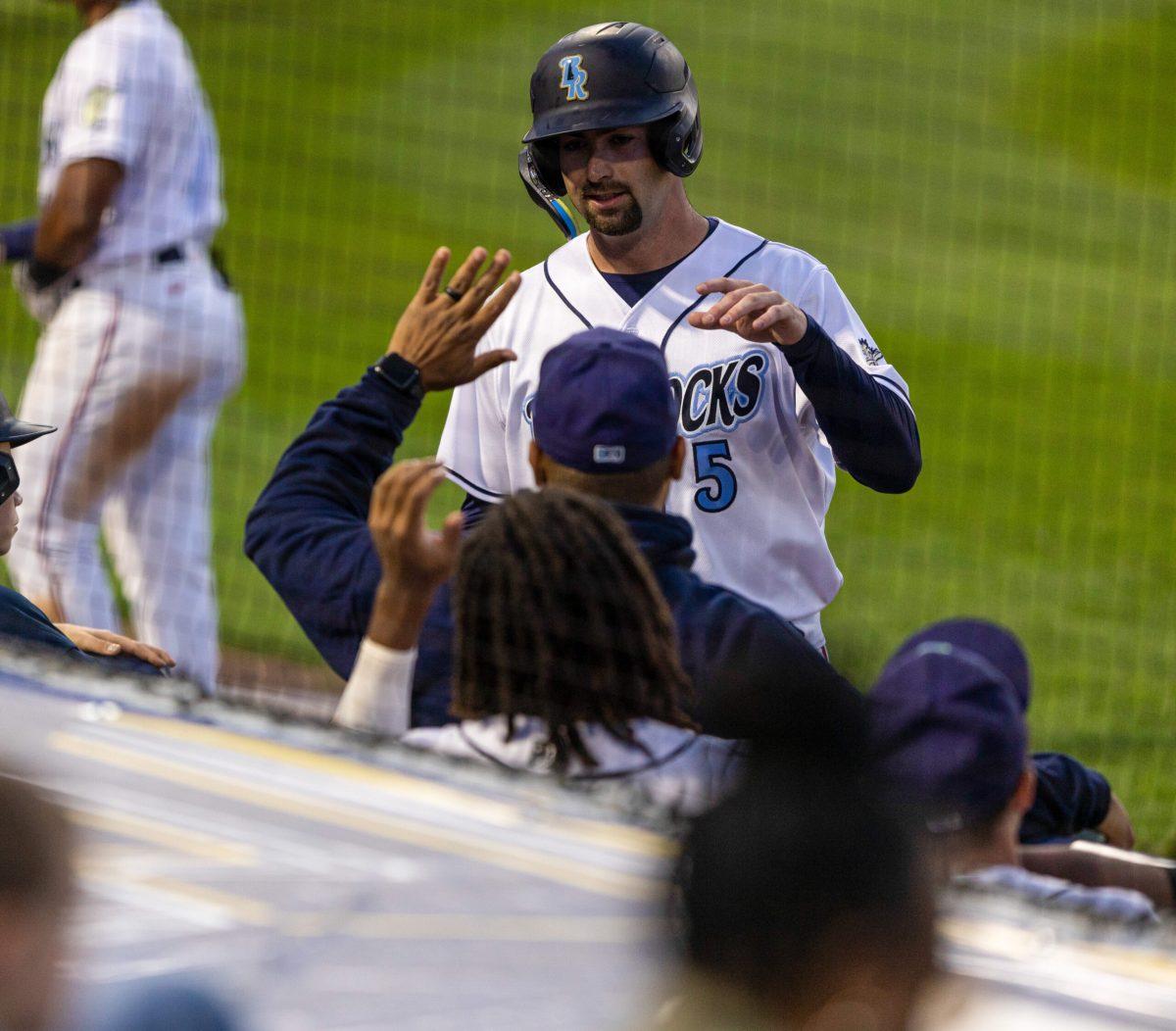 Will Frizzell high fives teammates on the way back to the dugout. Thursday, May 25, 2023. - Staff Photographer / Joe Capuyan 