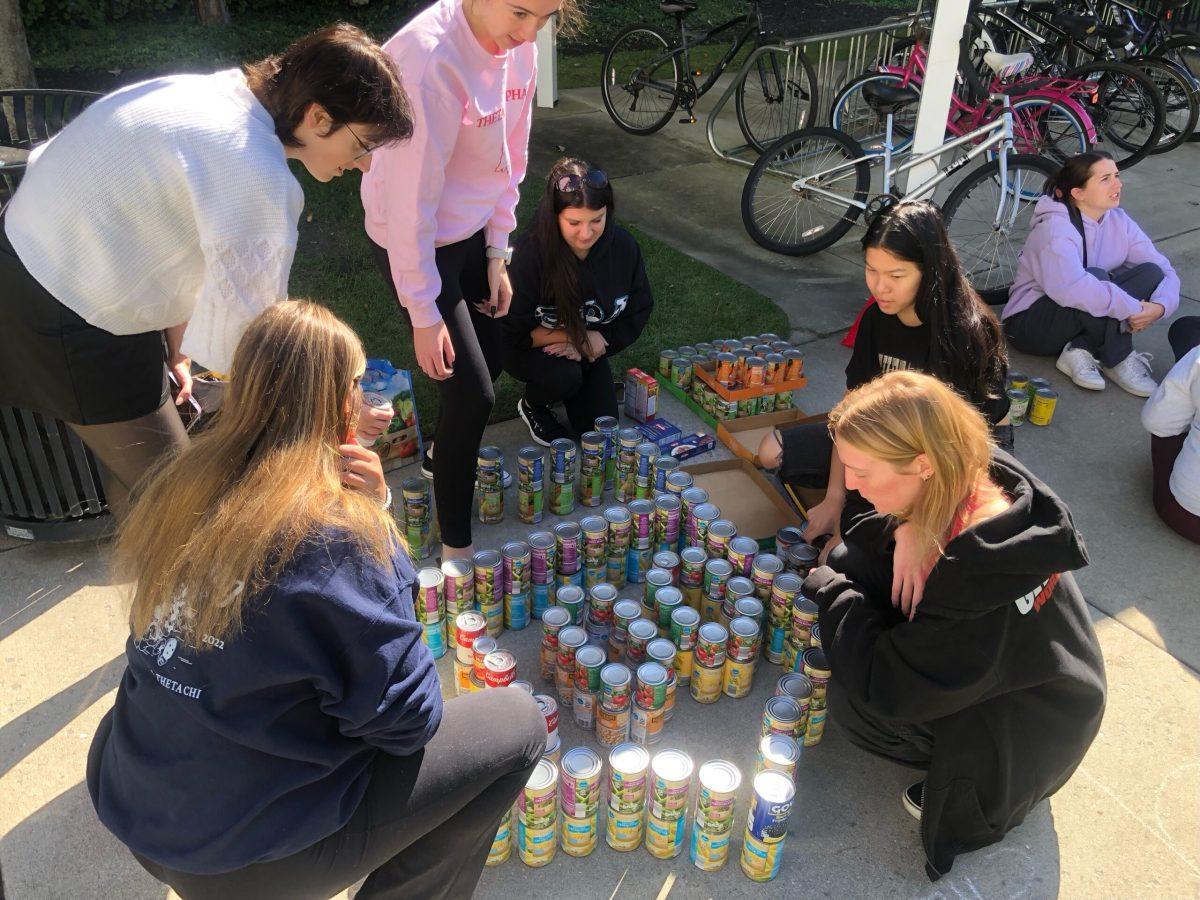 Theta Phi Alpha sorority works on NFL-inspired logo at CANstruction. - Staff Writer / Jose Ascencio