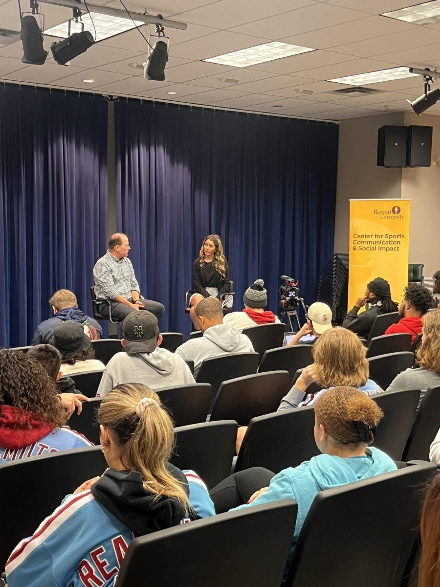 Neil Hartman and Kayla Santiago speak in front of crowd of students. - Photo via @RowanSportsCAM on X, formerly known as Twitter