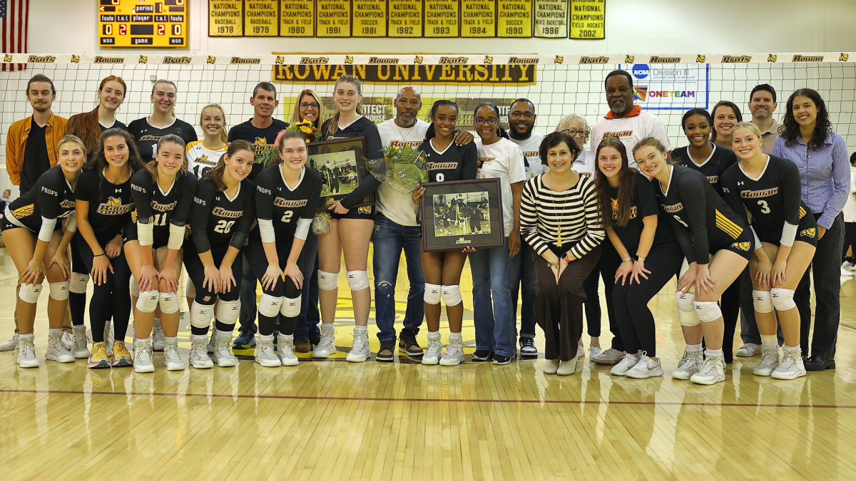 The team gathers around Alexa Blue (left) and Sydni Greenwood (right) pregame for Senior Night. Blue and Greenwood were honored as the team's two seniors. - Photo via Rowan Athletics