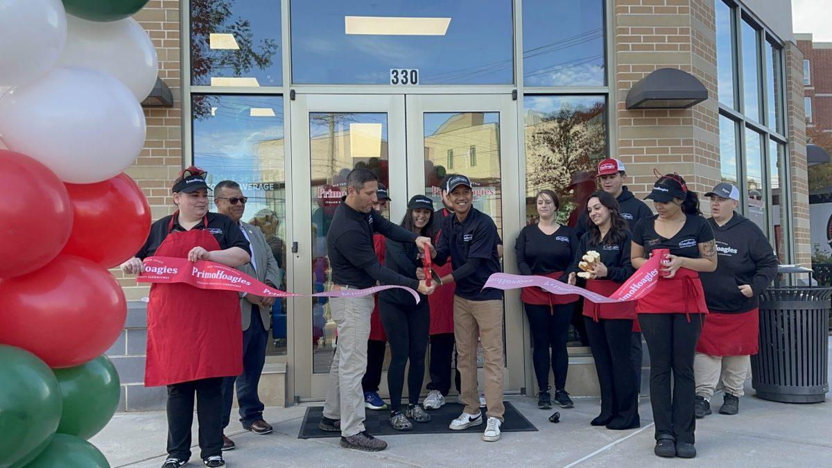 Primo Hoagies staff cut a ribbon in front of their newly opened location. - Copy Editor / Bryant Lopez