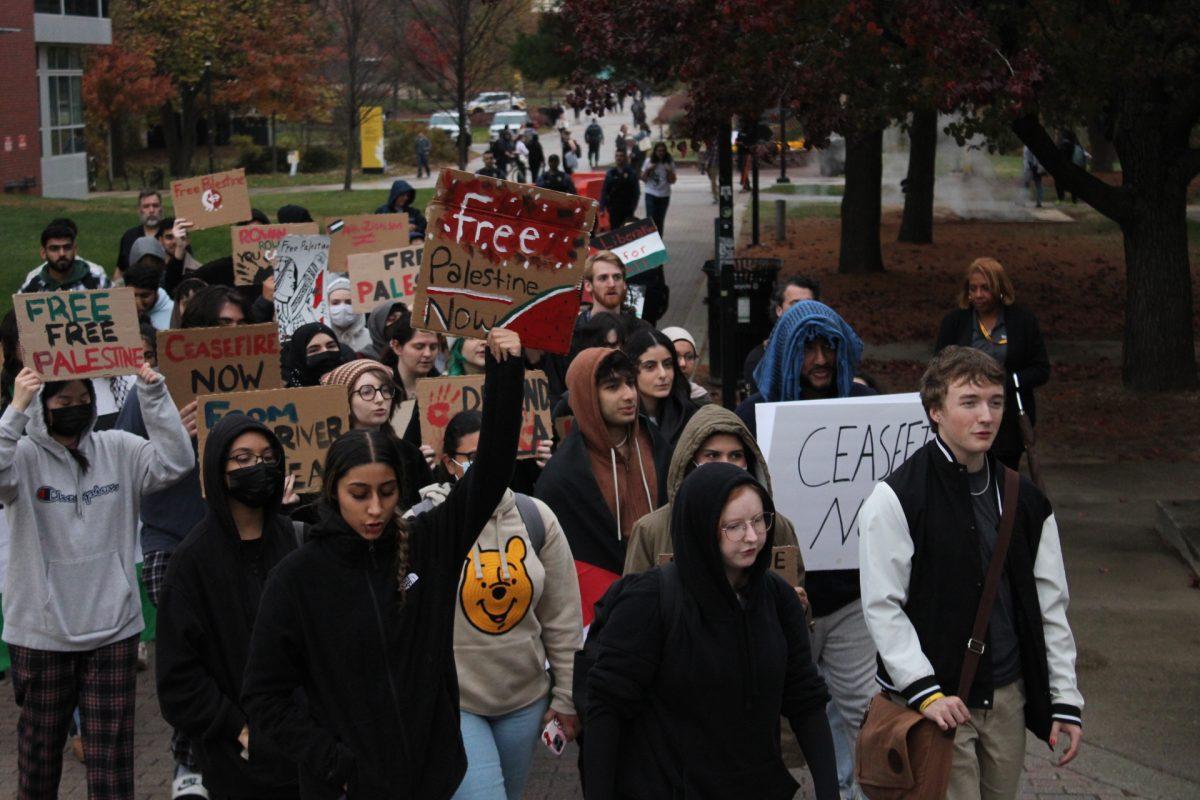 Students march down Discovery Walk while chanting "Free, free Palestine" while holding signs. Arts & Entertainment Editor / Al Harmon