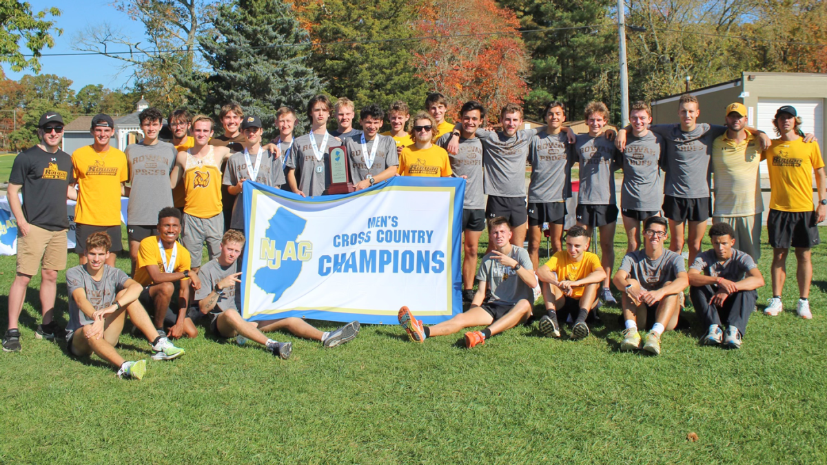 The Rowan men's cross country team poses with their championship banner. This past Saturday, they secured their first back-to-back NJAC Championship in 30 years. - Photo via Rowan Athletics