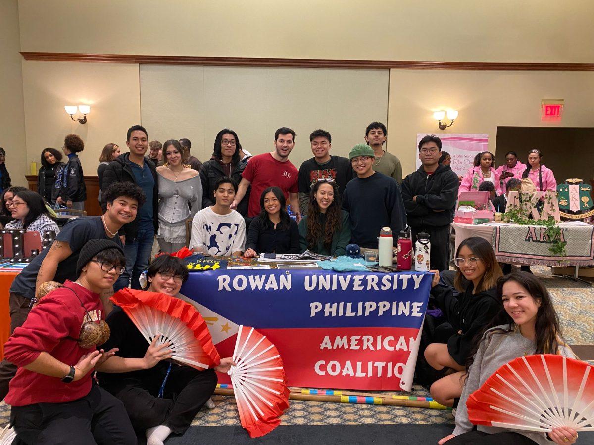 Rowan University Philippine American Coalition (RUPAC) members pose with their table. - Contributor / Erik Gil