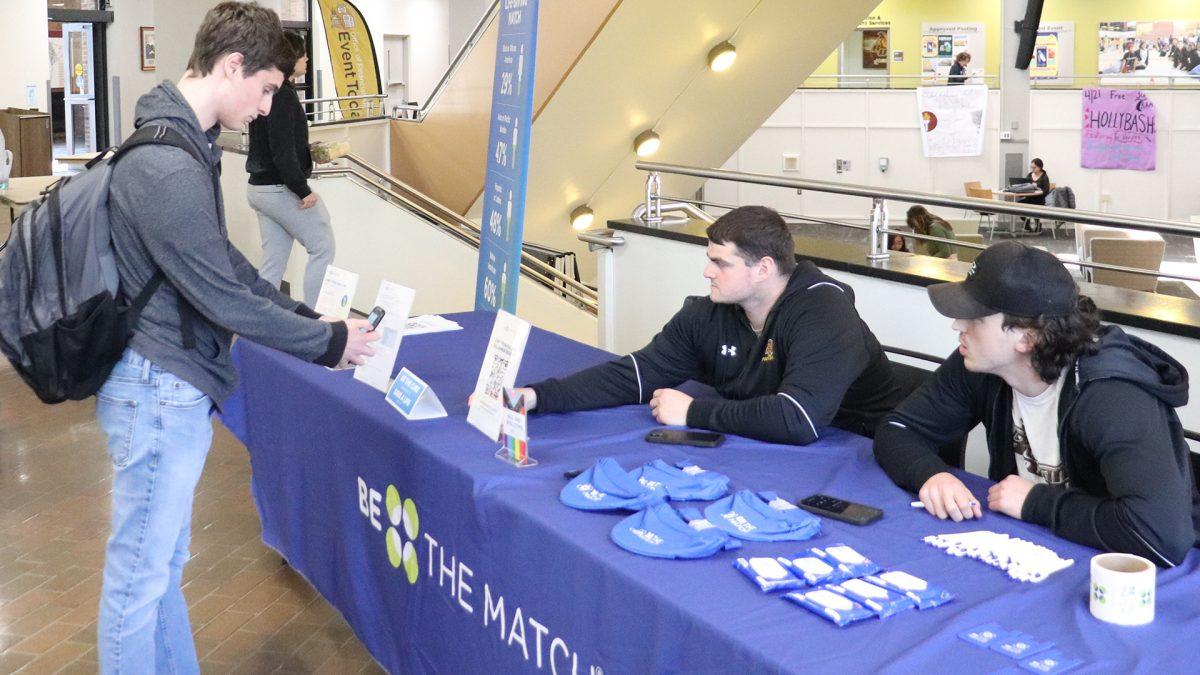 A student scans the QR code to find out more information about the Bone Marrow drive. The football team will be hosting the drive on Wednesday, April 24, at the Chamberlain Student Center. - Photo via Rowan Athletics