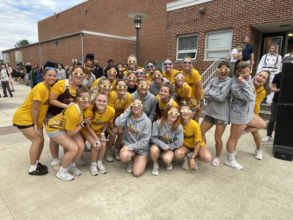 Rowan women's lacrosse players pose with their eclipse glasses on Robinson Green. - Staff Writer / Brendan Cohen